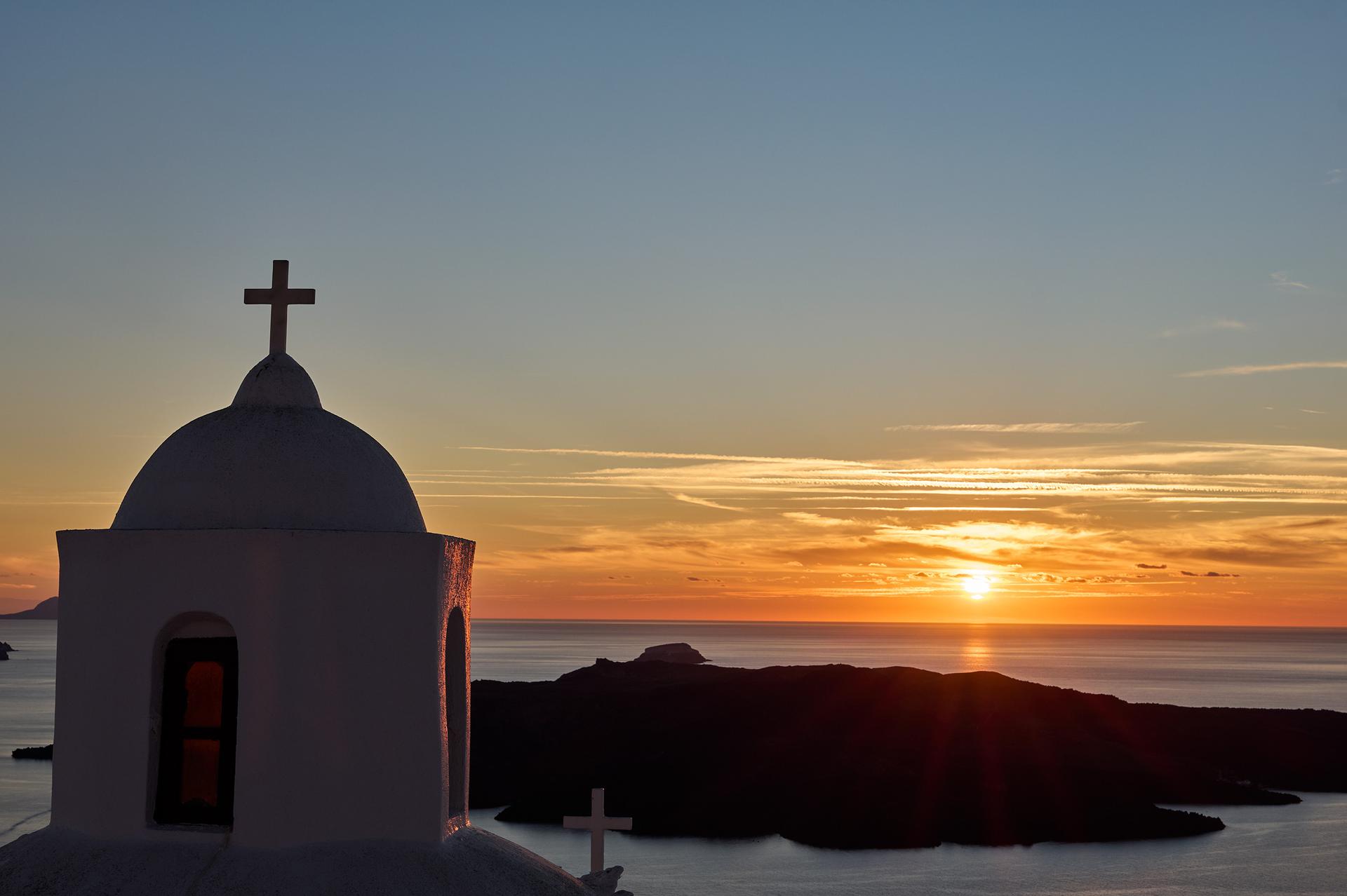 Sunset view through terrace with church domes at Aroma Suites Santorini